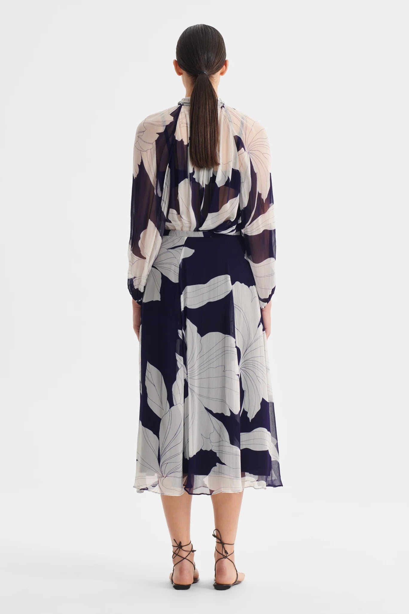 Woman wearing a blue and white blouse and matching skirt on a white background