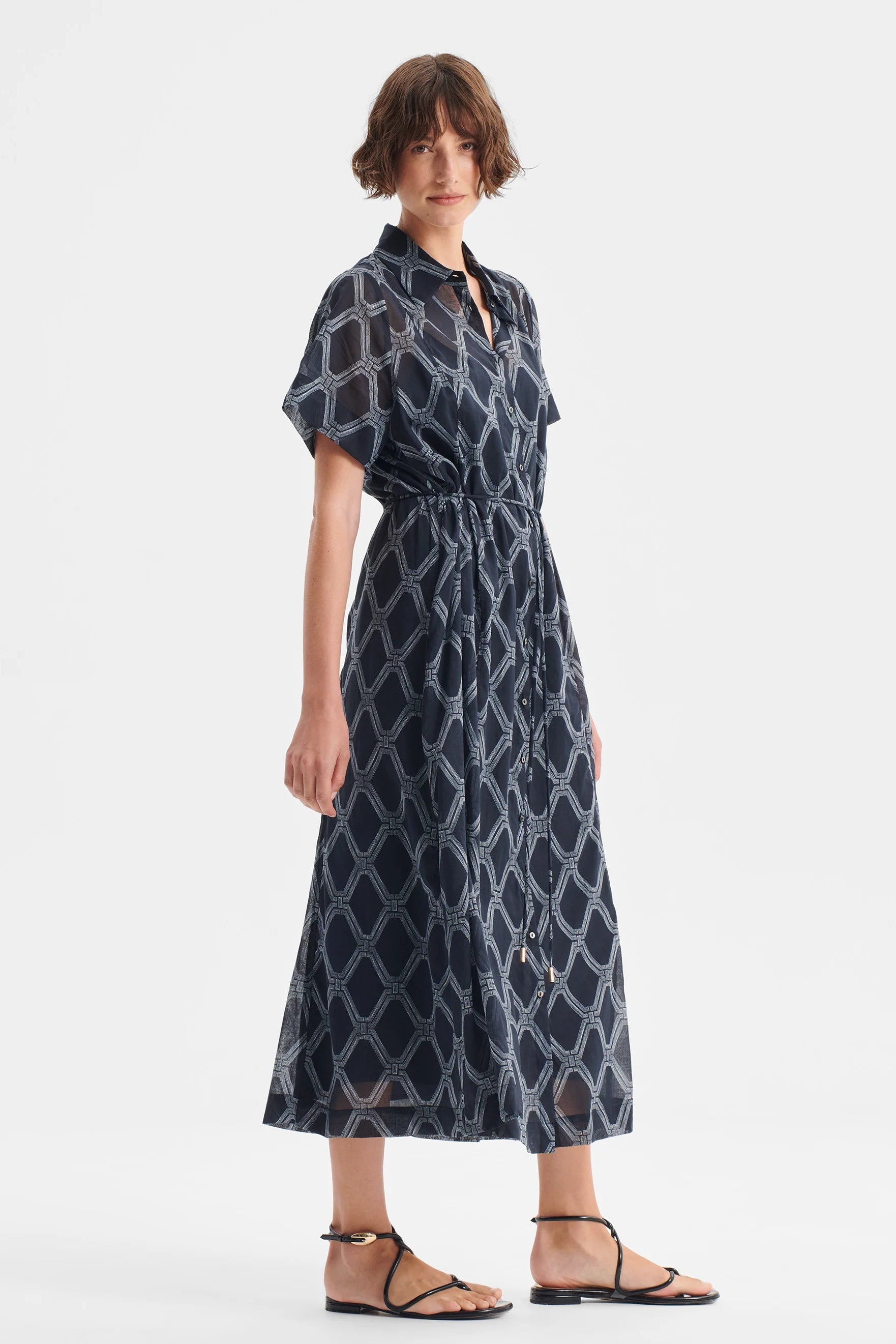 Woman wearing a patterned dress on a white background