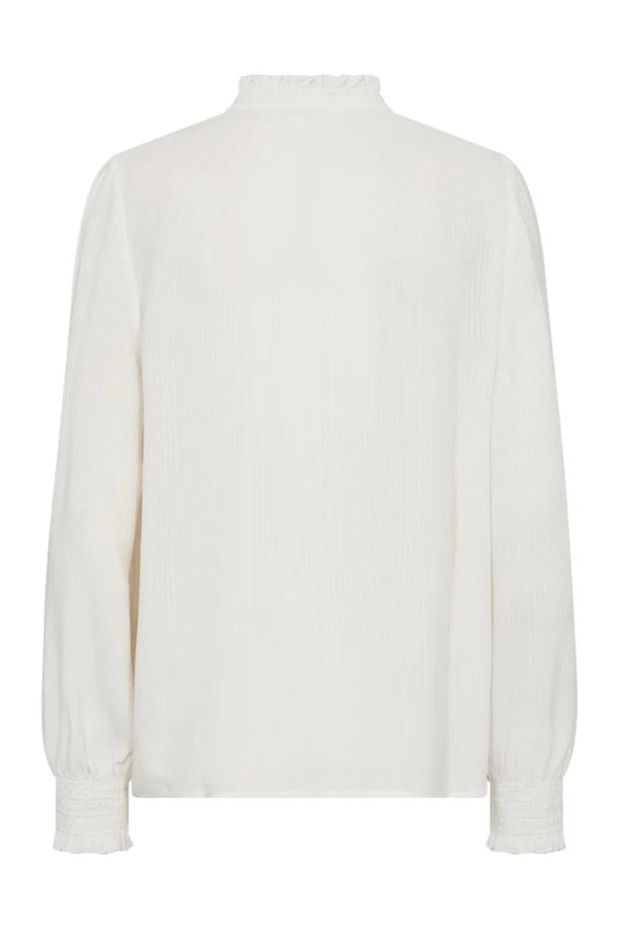 Ecru shirt with front ruffle placket and smock detail at sleeve. 