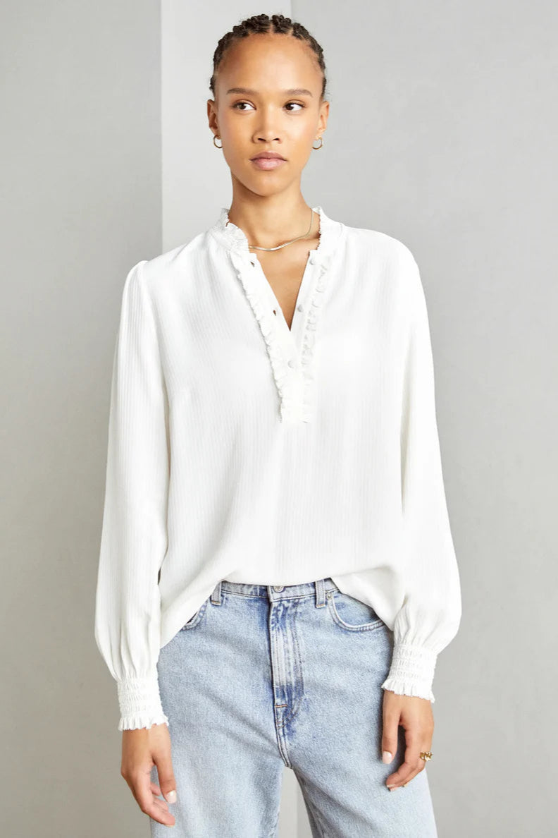 Ecru shirt with front ruffle placket and smock detail at sleeve. 