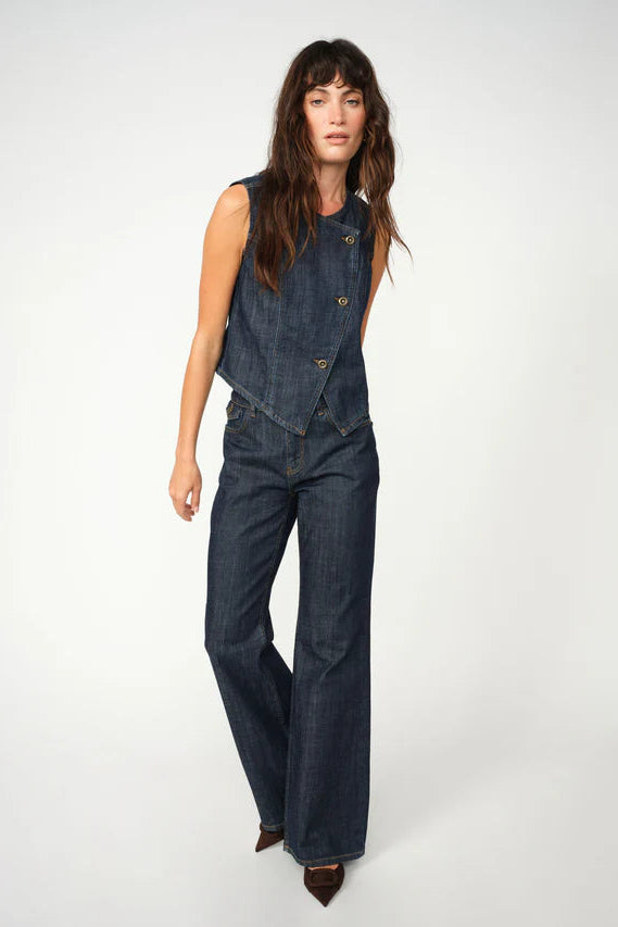 Woman wearing a denim vest and jeans on a white background