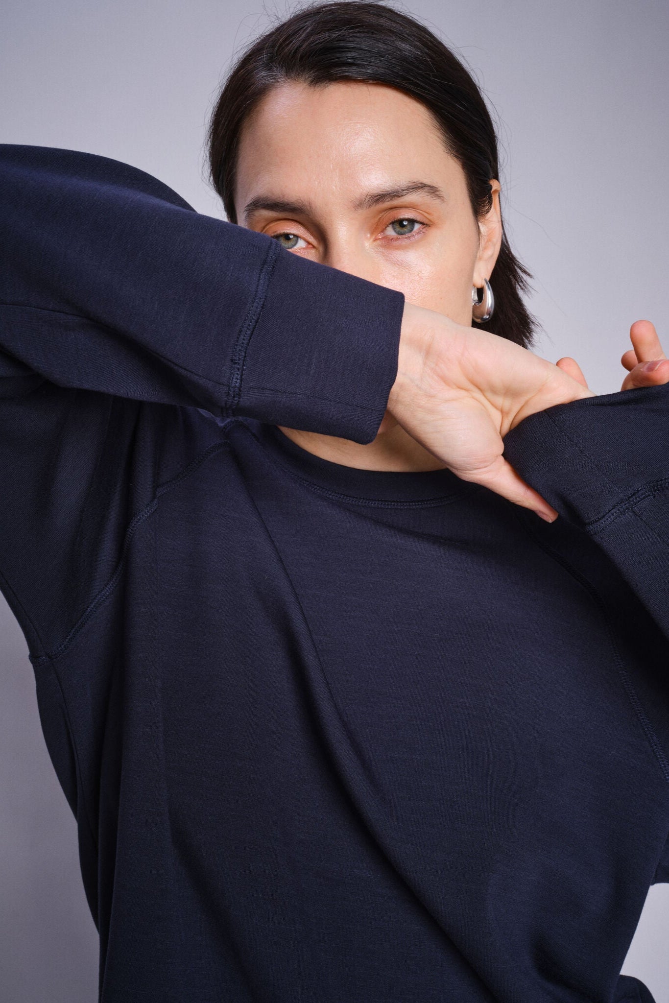 Model wearing a navy blue crew neck sweatshirt on a white background