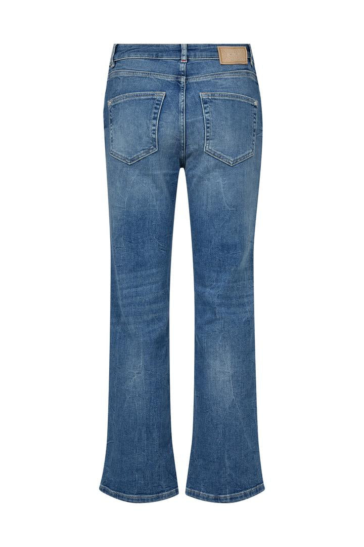 Blue slightly flared cropped jeans in mid blue on a white background