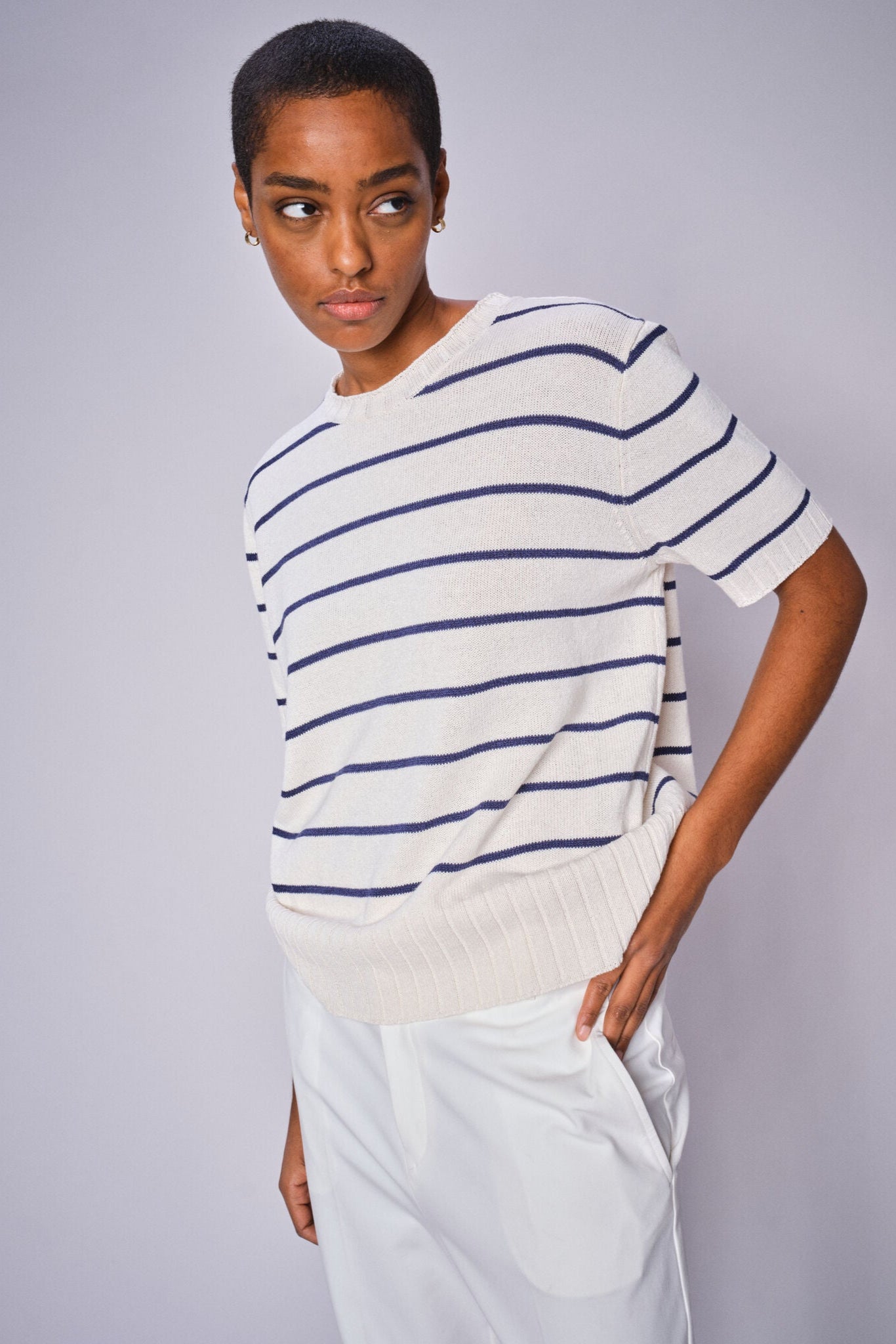 Model wearing white and blue strip short sleeve knit top and white cropped pants.