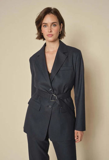 Deep Navy Blazer with double-button closure, flap pockets, and a subtle rounded hem and belt.