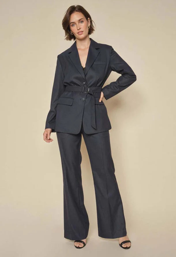 Deep Navy Blazer with double-button closure, flap pockets, and a subtle rounded hem and belt.