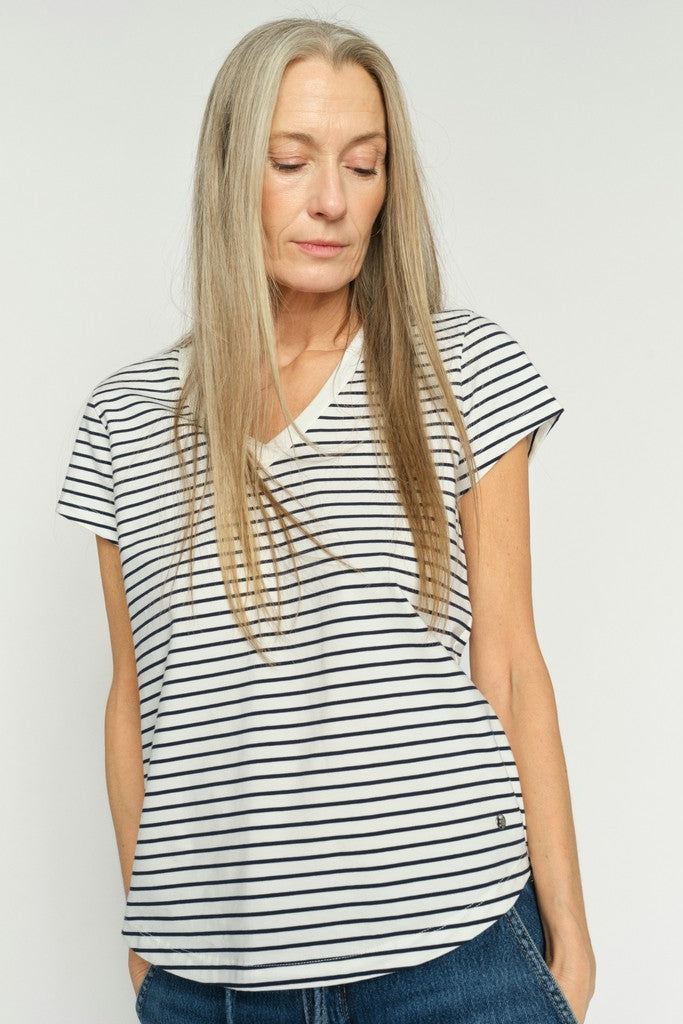 Woman wearing a navy and white striped v neck tee shirt against a plain background