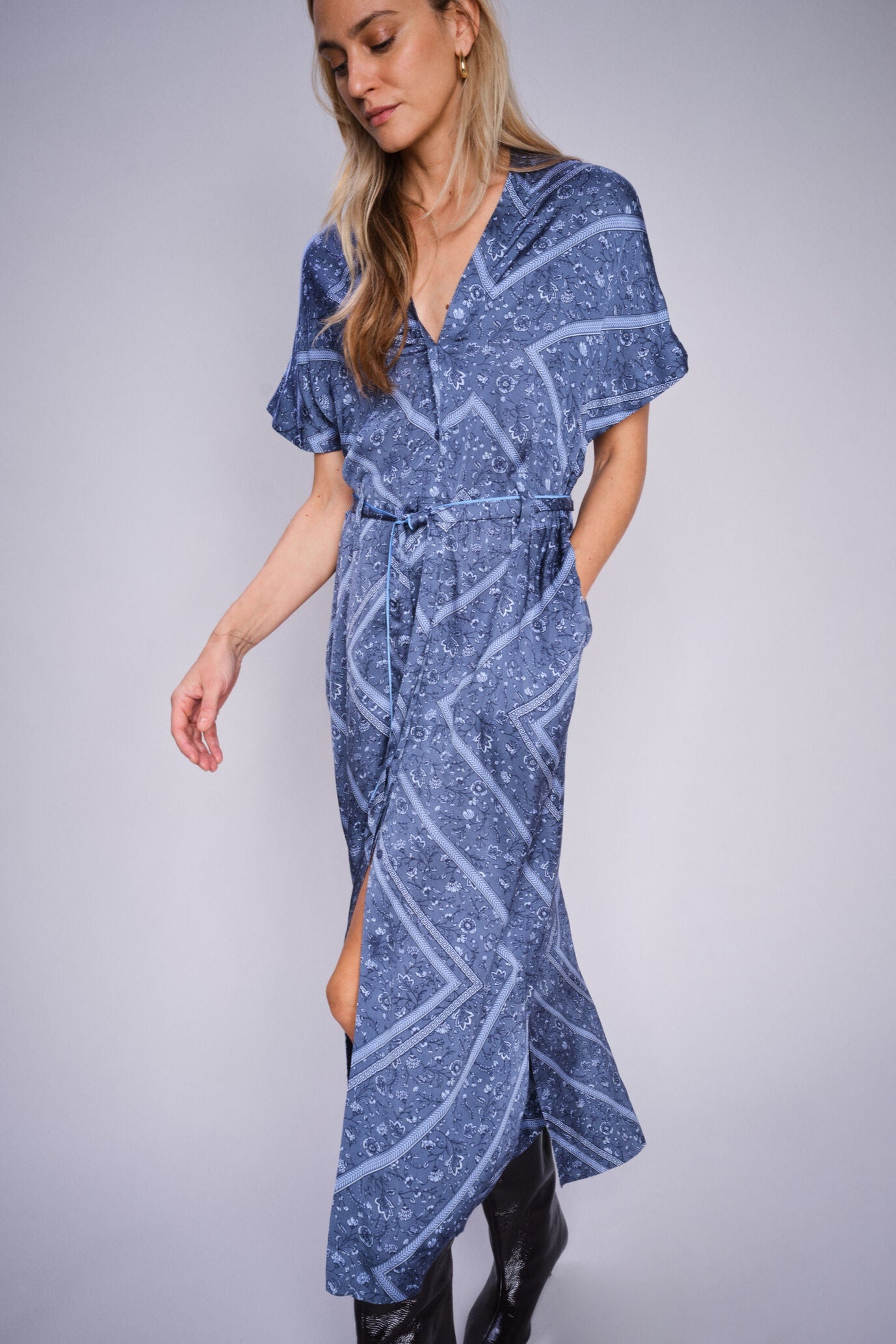 Woman wearing a blue patterned dress on a gray background