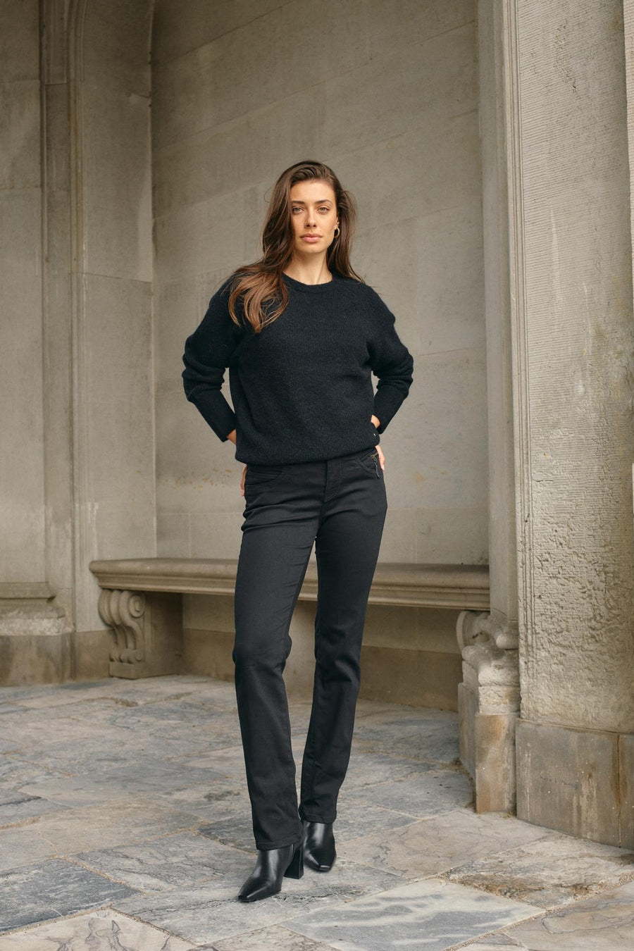 Black tapered jean with mid rise and zip detail at left front pocket. 