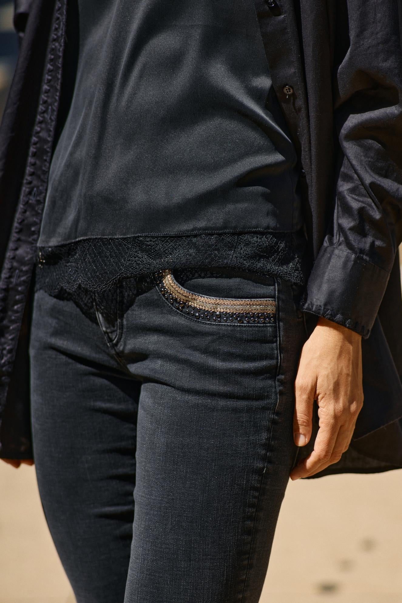 Black wash tapered leg jean with sequin pocket details. 