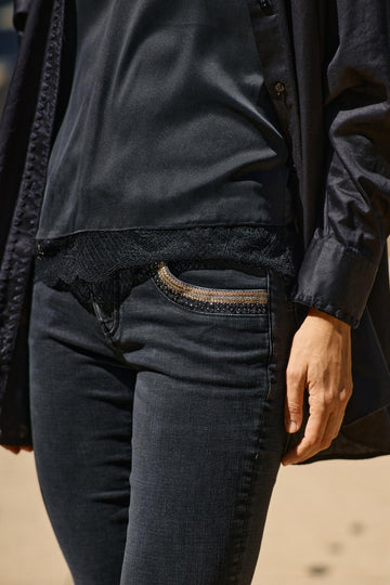 Black wash tapered leg jean with sequin pocket details. 