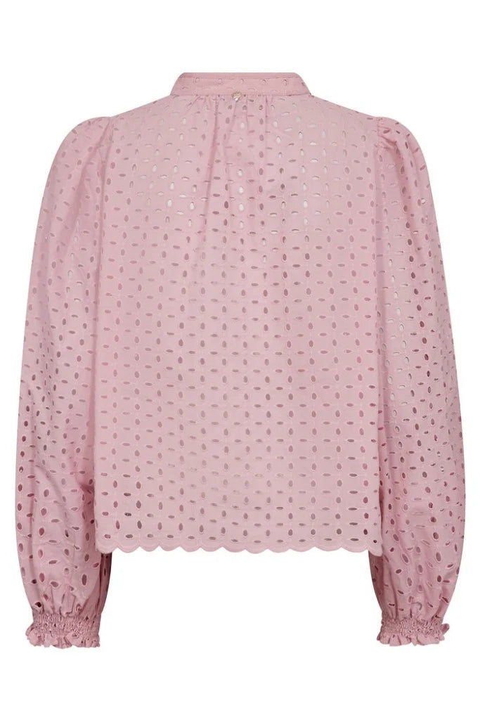 A light pink broderie  blouse with long balloon sleeves, a gathered high collar, and a scalloped hem, shown against a plain white background.