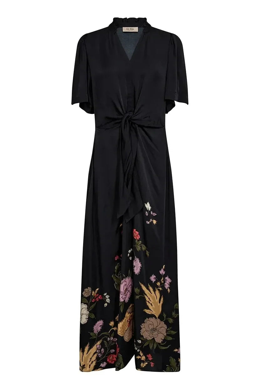 A black wrap-style maxi dress with short flutter sleeves, a V-neckline, a front waist tie, and a floral print concentrated along the lower skirt, shown on a plain white background.