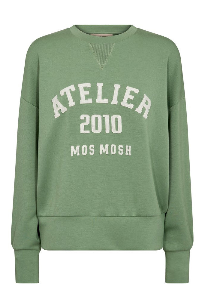 A sage green crewneck sweatshirt with 'ATELIER 2010 MOS MOSH' printed in white on the front, displayed on a clean white background.