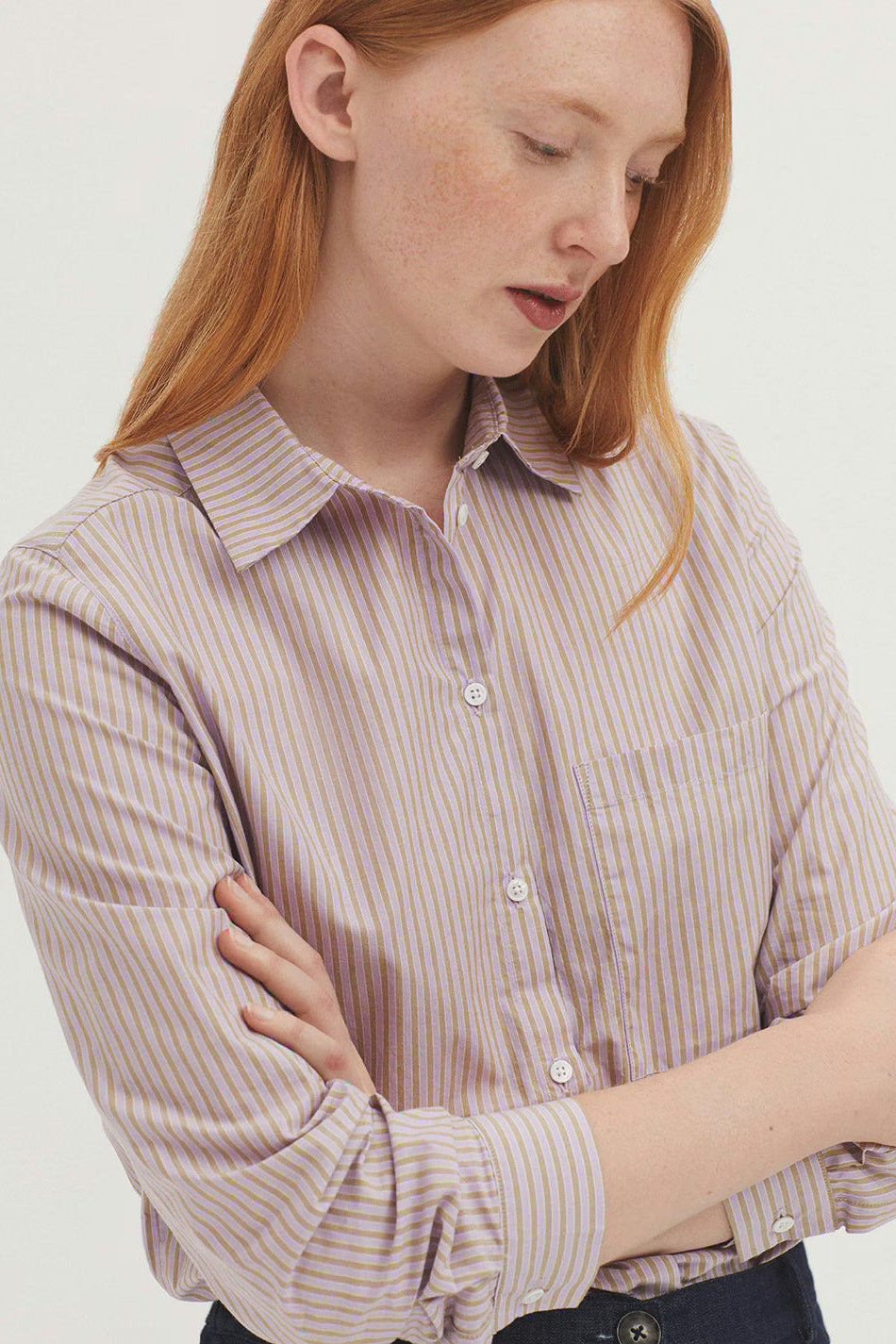 Woman wearing a striped shirt against a plain background