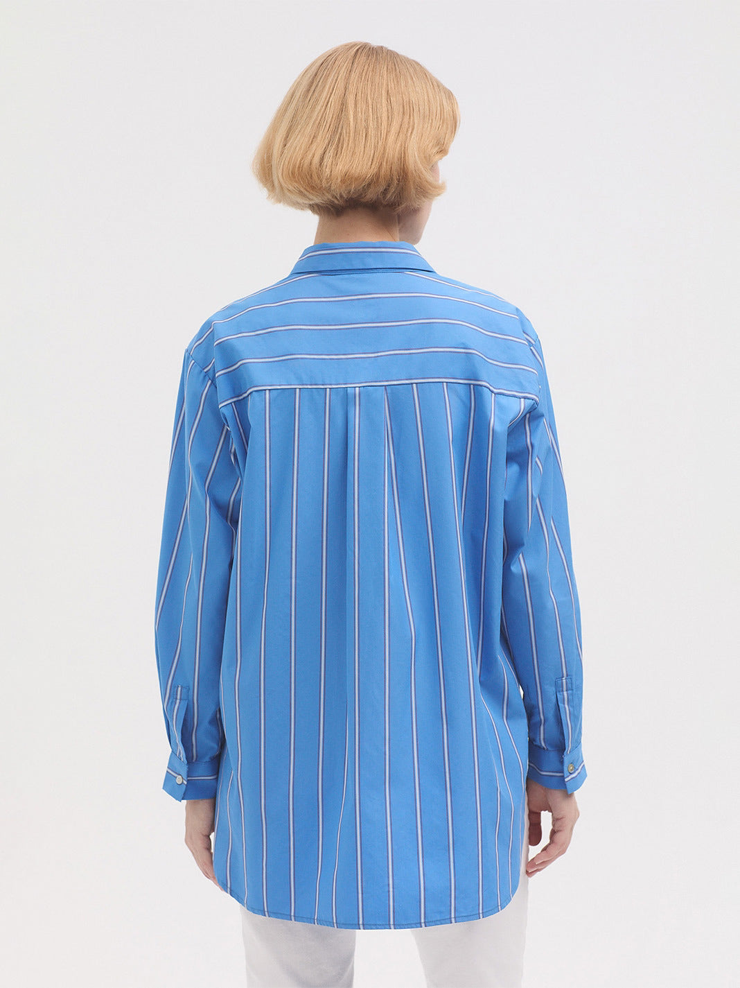 Person wearing a blue striped shirt on a white background