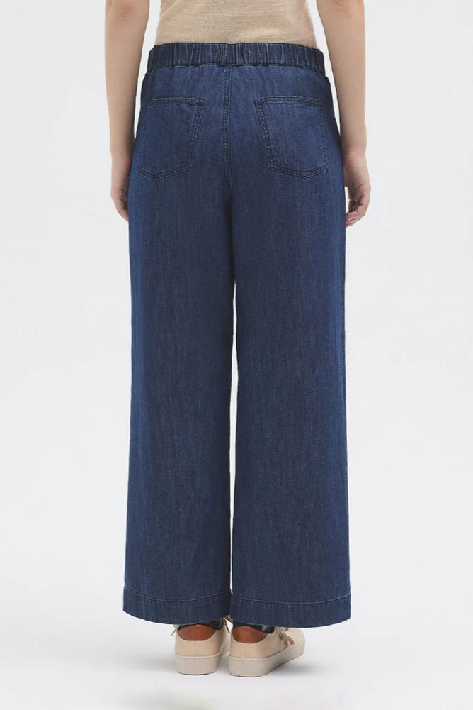 Model wearing wide leg denim jean with t shirt and trainers. 