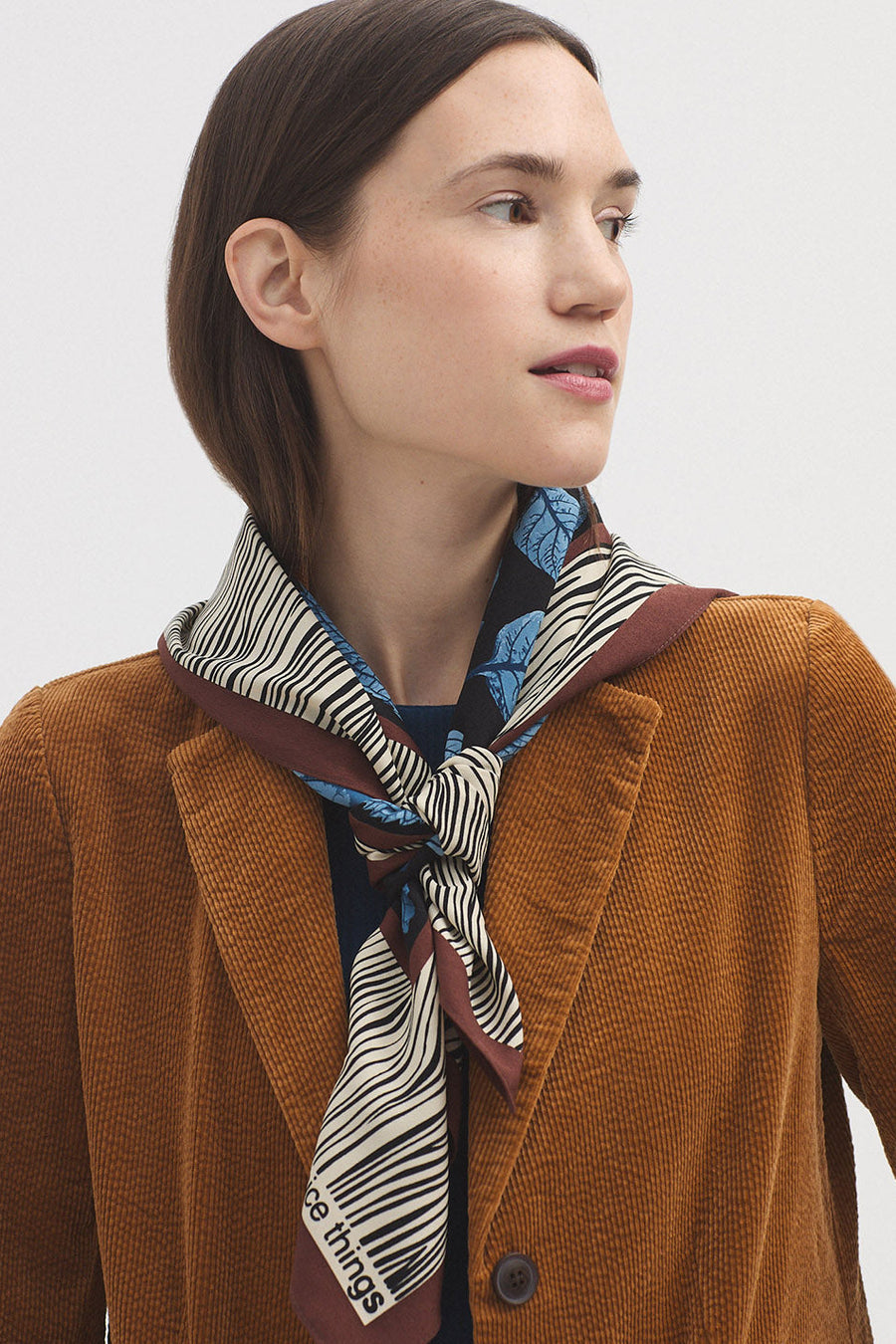 Scarf with all over print in brown and ecru with blue leaves. 