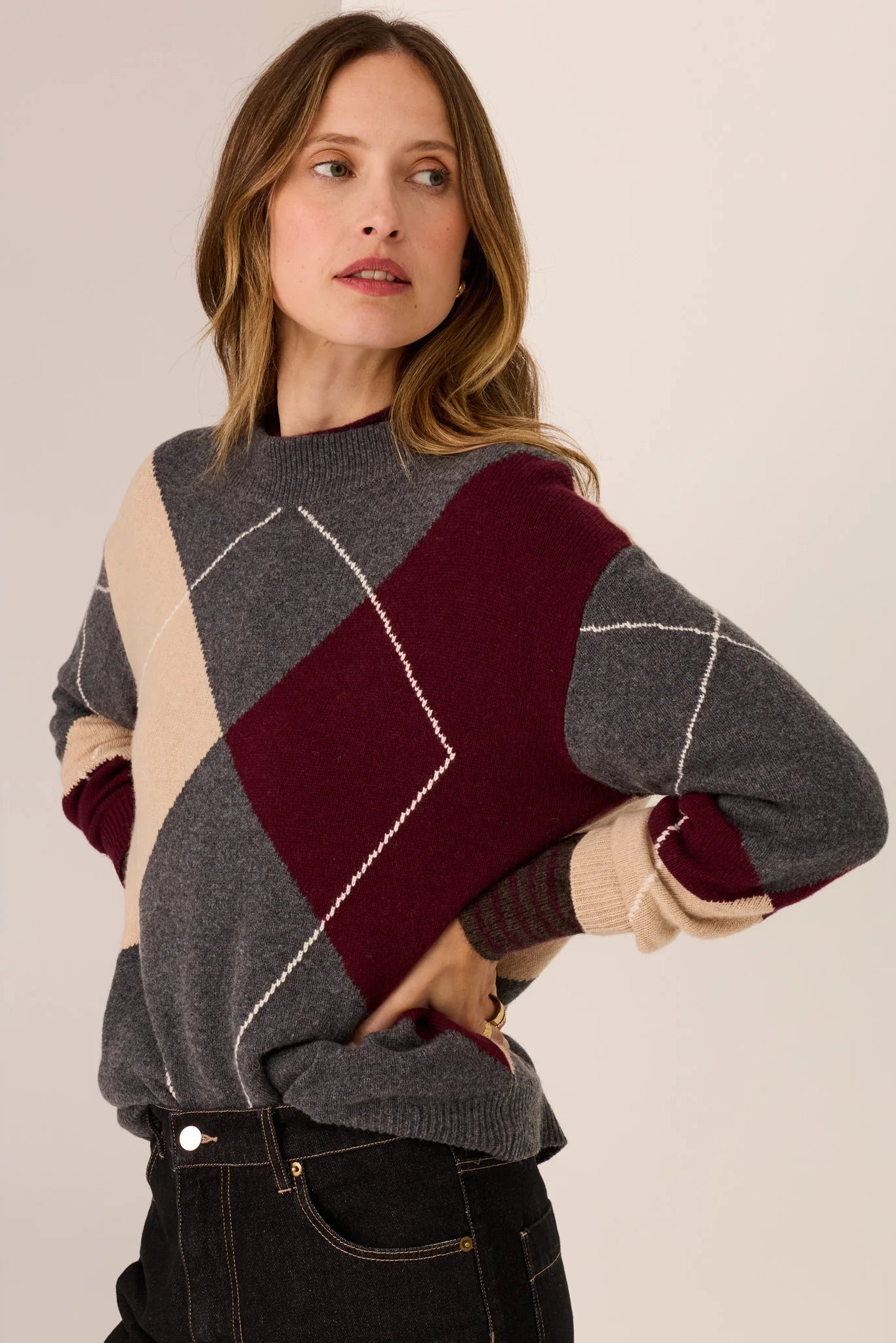 Woman wearing a patterned sweater against a plain background