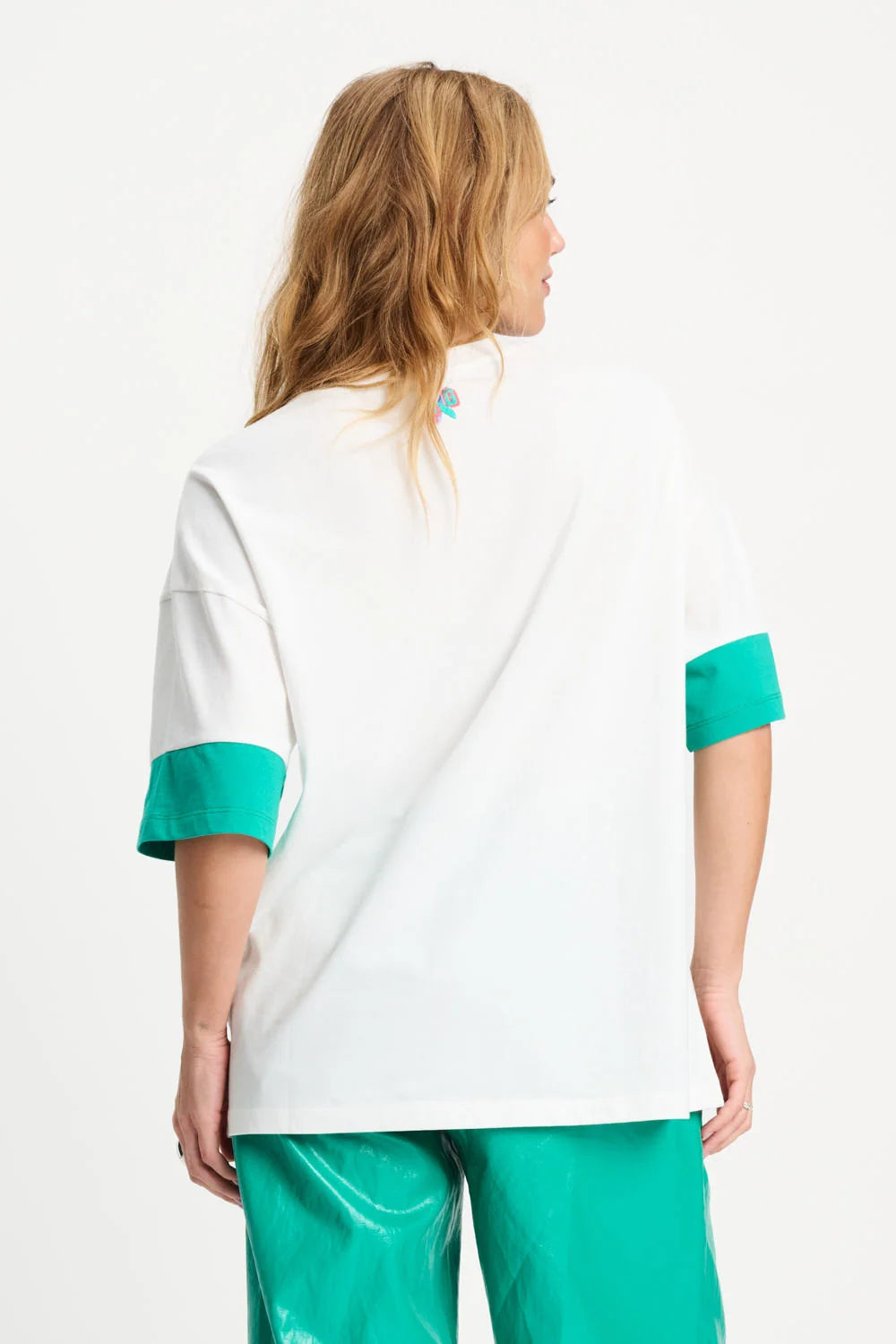 Woman wearing a white and teal outfit on a white background