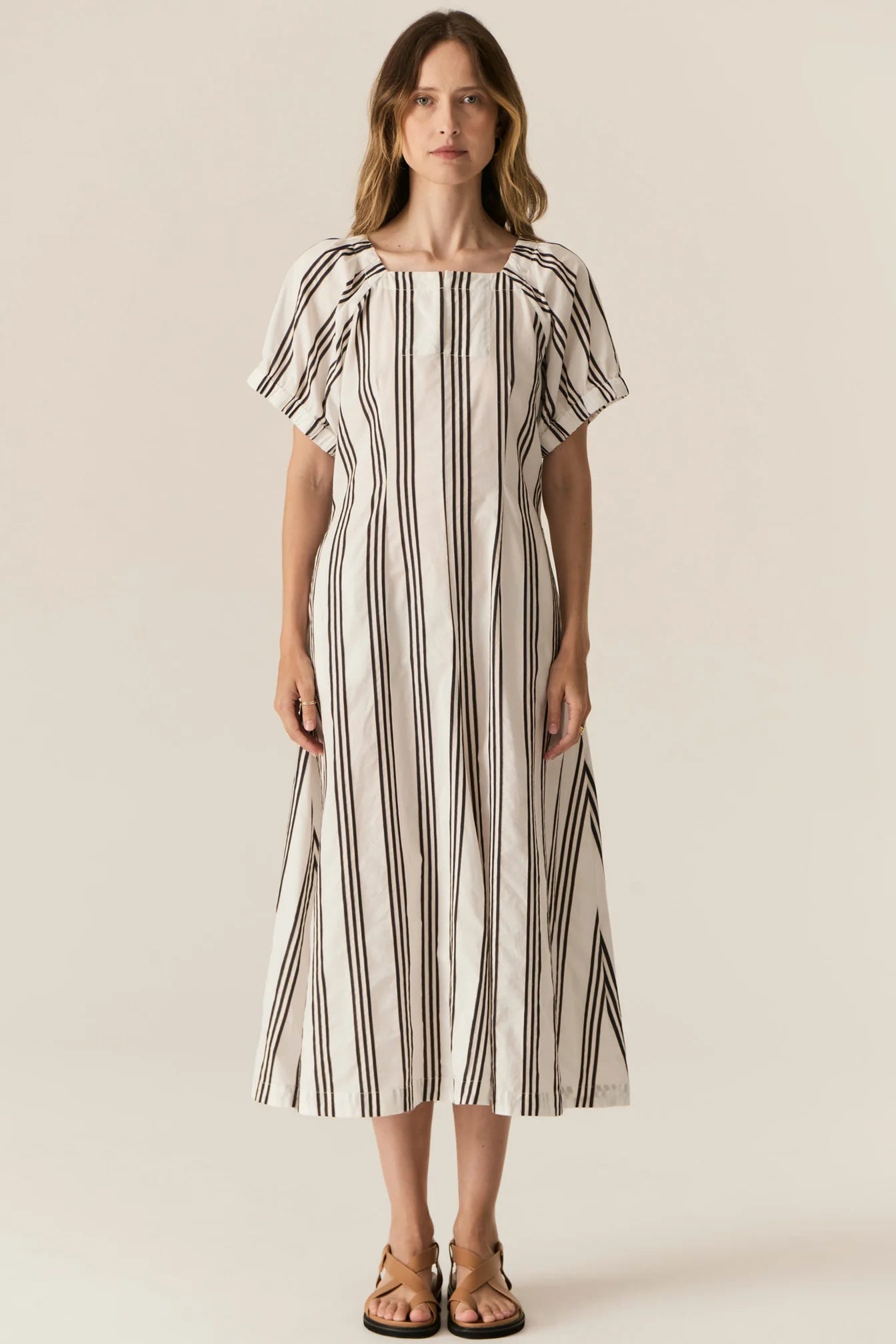 Woman wearing a striped dress on a plain background