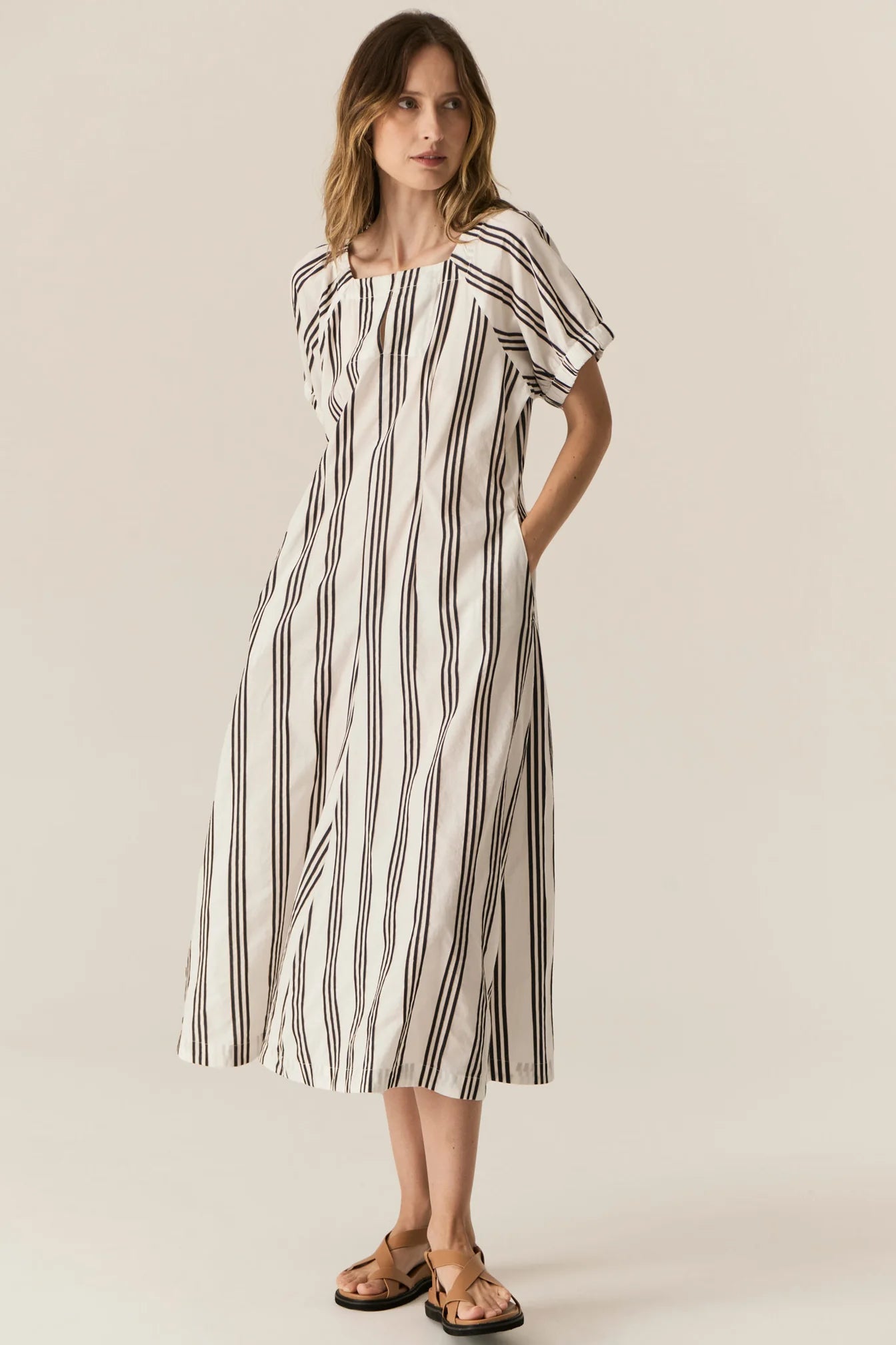 Woman wearing a striped dress on a plain background