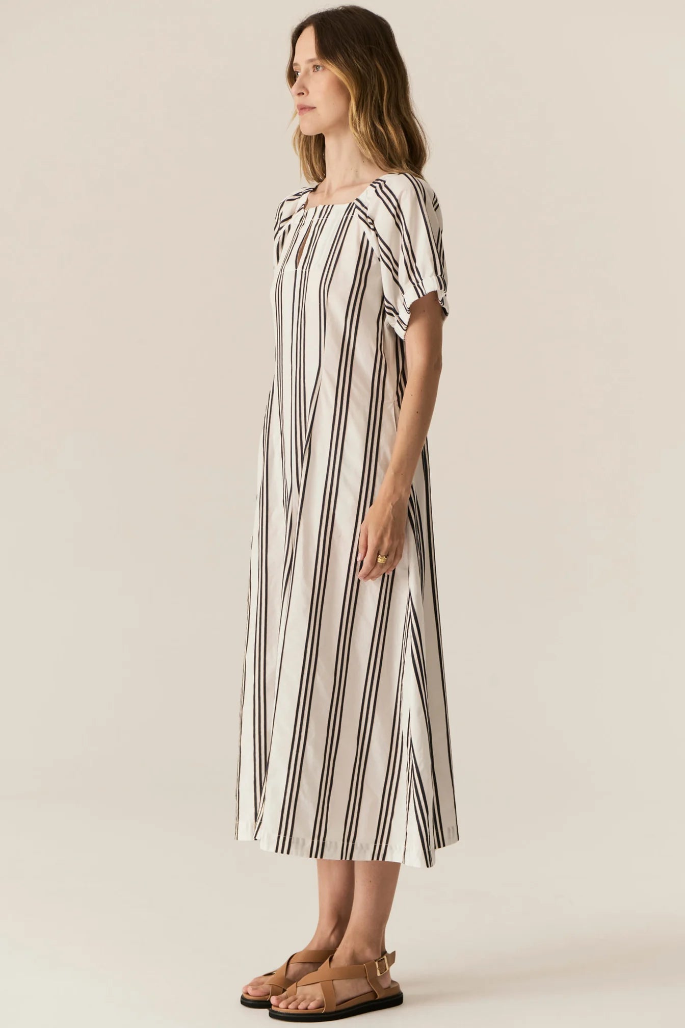 Woman wearing a striped dress on a plain background