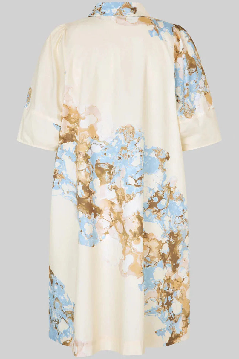 A cream-colored short-sleeve kimono-style top with a watercolor-style abstract floral print in light blue and brown, shown from the back against a solid gray background.