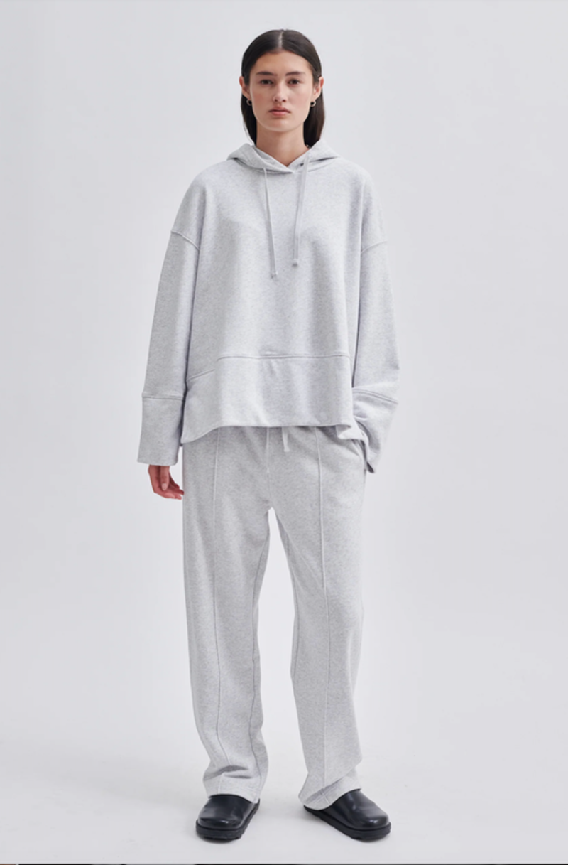 Model wearing a grey hoodie and grey track pants. 