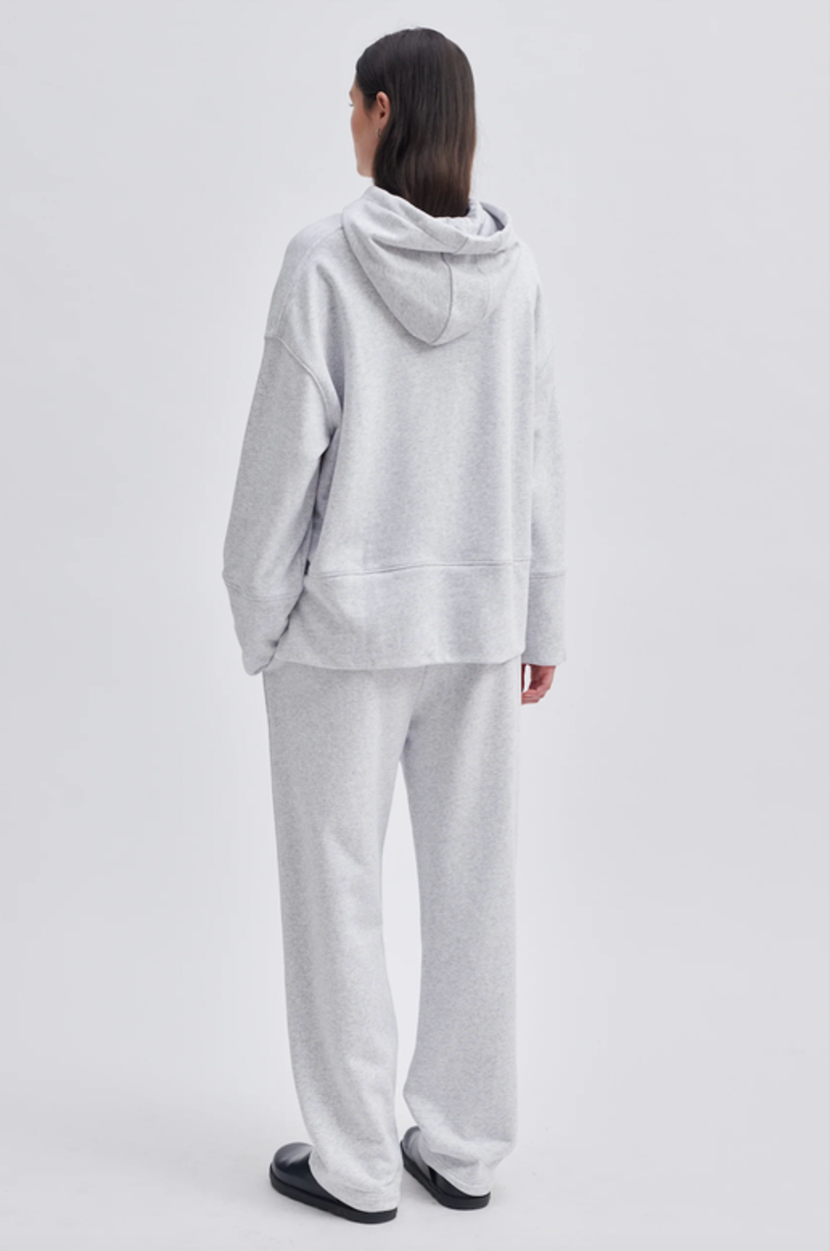 Model wearing a grey hoodie and grey track pants. 
