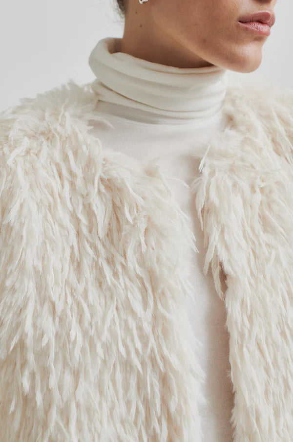 Model wearing Shaggy cream jacket with long sleeve cropped. Paired with cream turtle neck top and cream pants. 