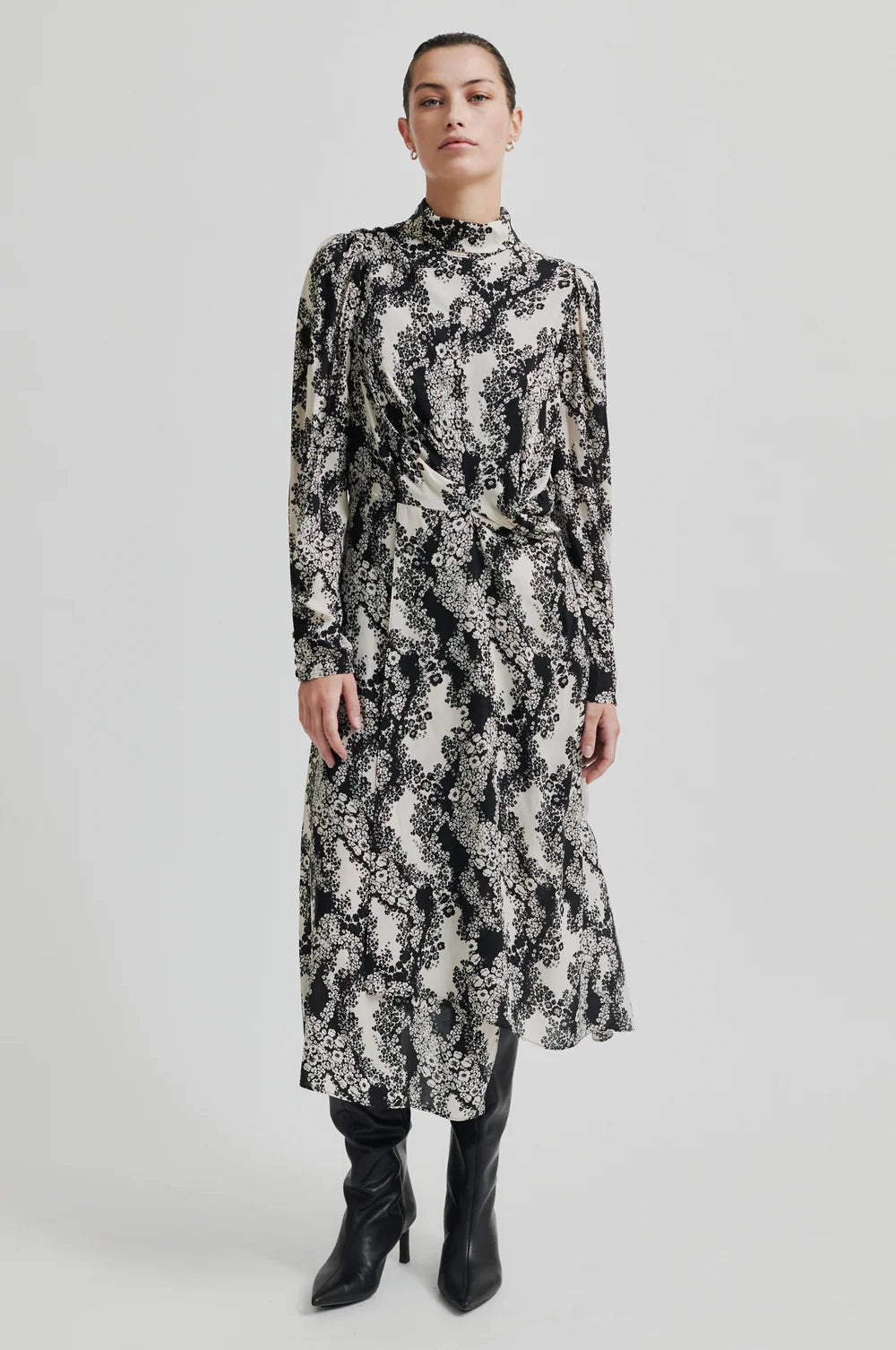 Long sleeve dress with a round, high neckline with keyhole opening at the back with button fastening. Black and white floral print. 