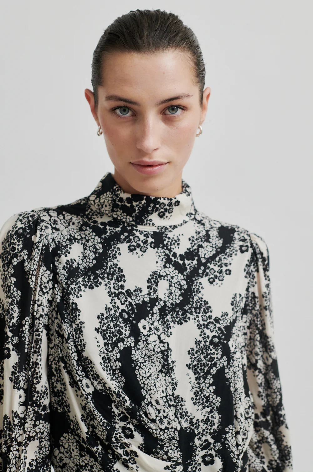 Long sleeve dress with a round, high neckline with keyhole opening at the back with button fastening. Black and white floral print. 