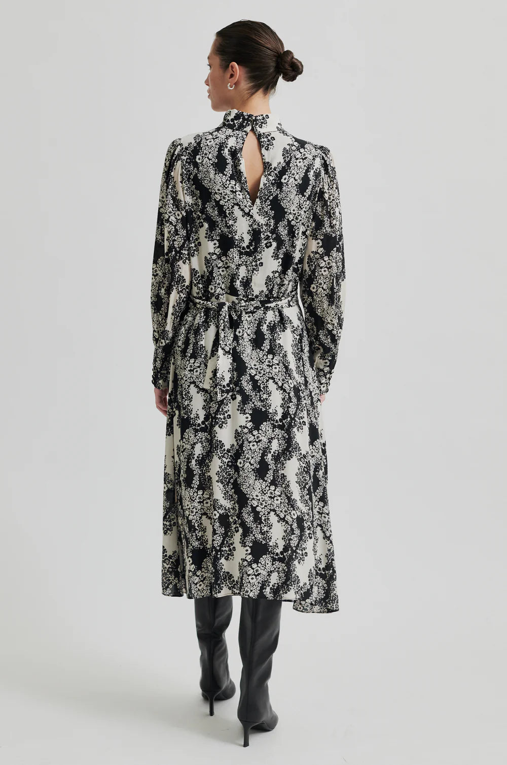 Long sleeve dress with a round, high neckline with keyhole opening at the back with button fastening. Black and white floral print. 