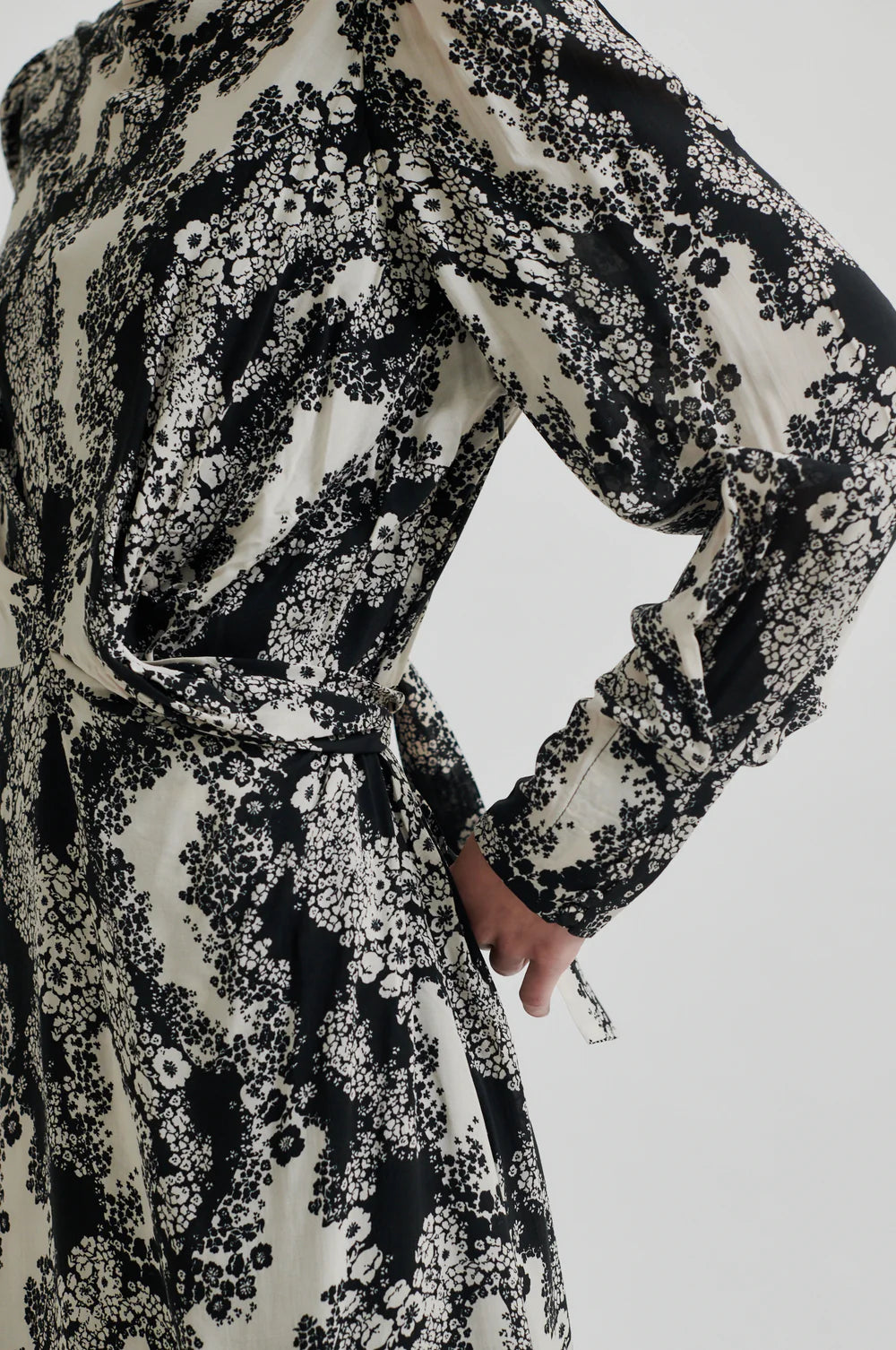 Long sleeve dress with a round, high neckline with keyhole opening at the back with button fastening. Black and white floral print. 