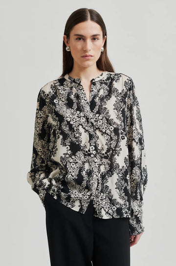 Black and cream floral print shirt with  placket with concealed button fastening and top visible button.