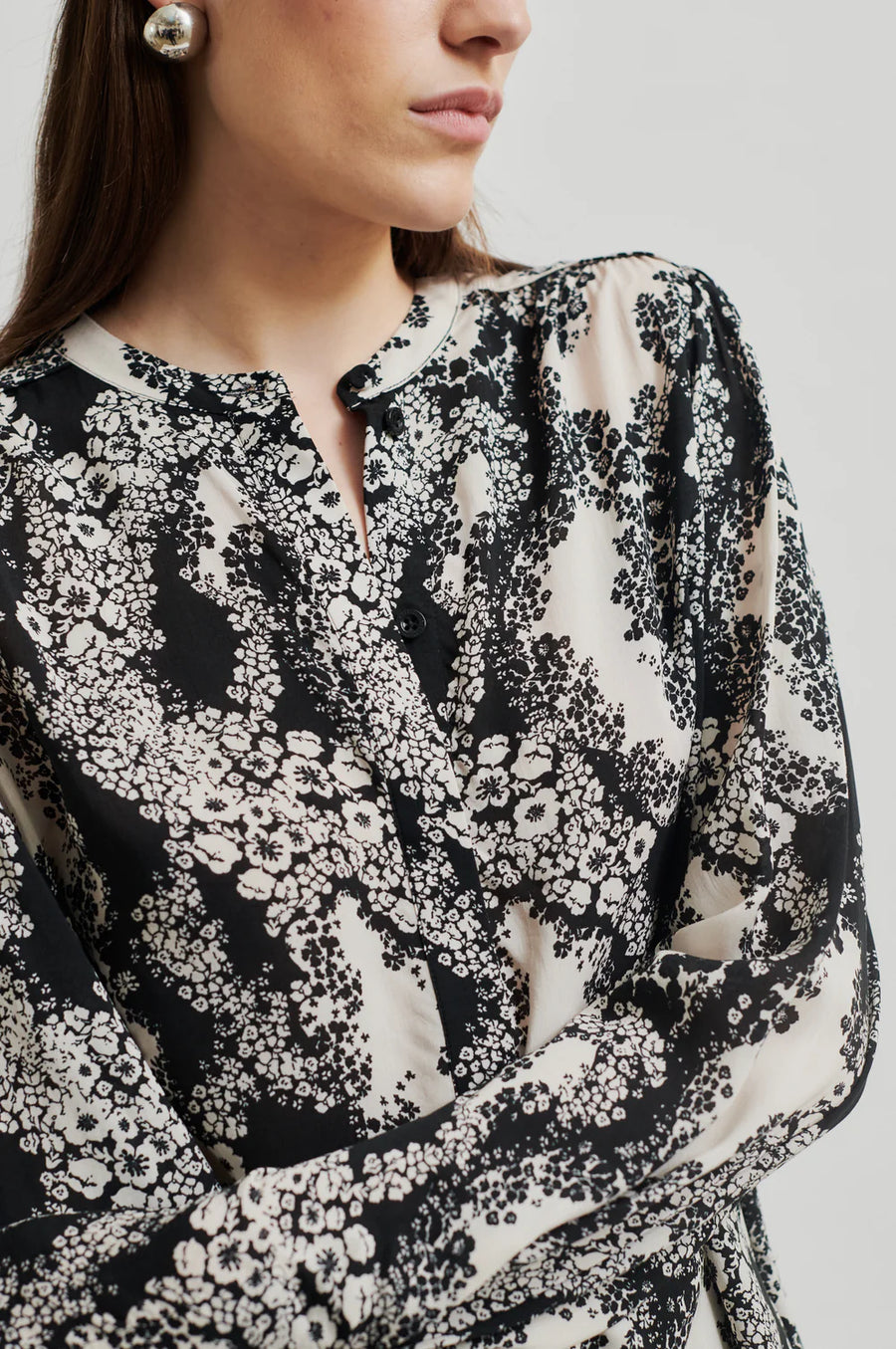 Black and cream floral print shirt with  placket with concealed button fastening and top visible button.