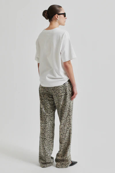 Model wearing mid rise wide leg leather pants with snake skin pattern and matching jacket. 