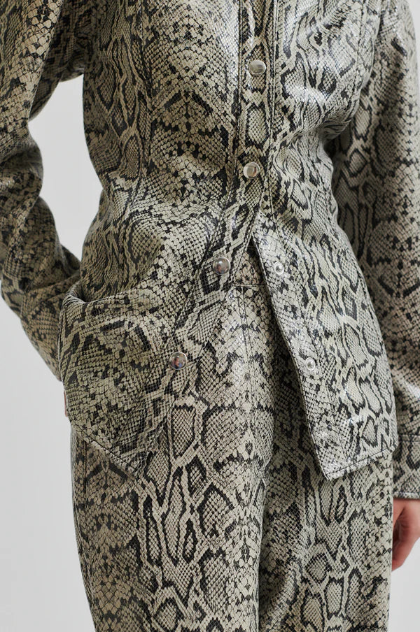 Model wearing mid rise wide leg leather pants with snake skin pattern and matching jacket. 