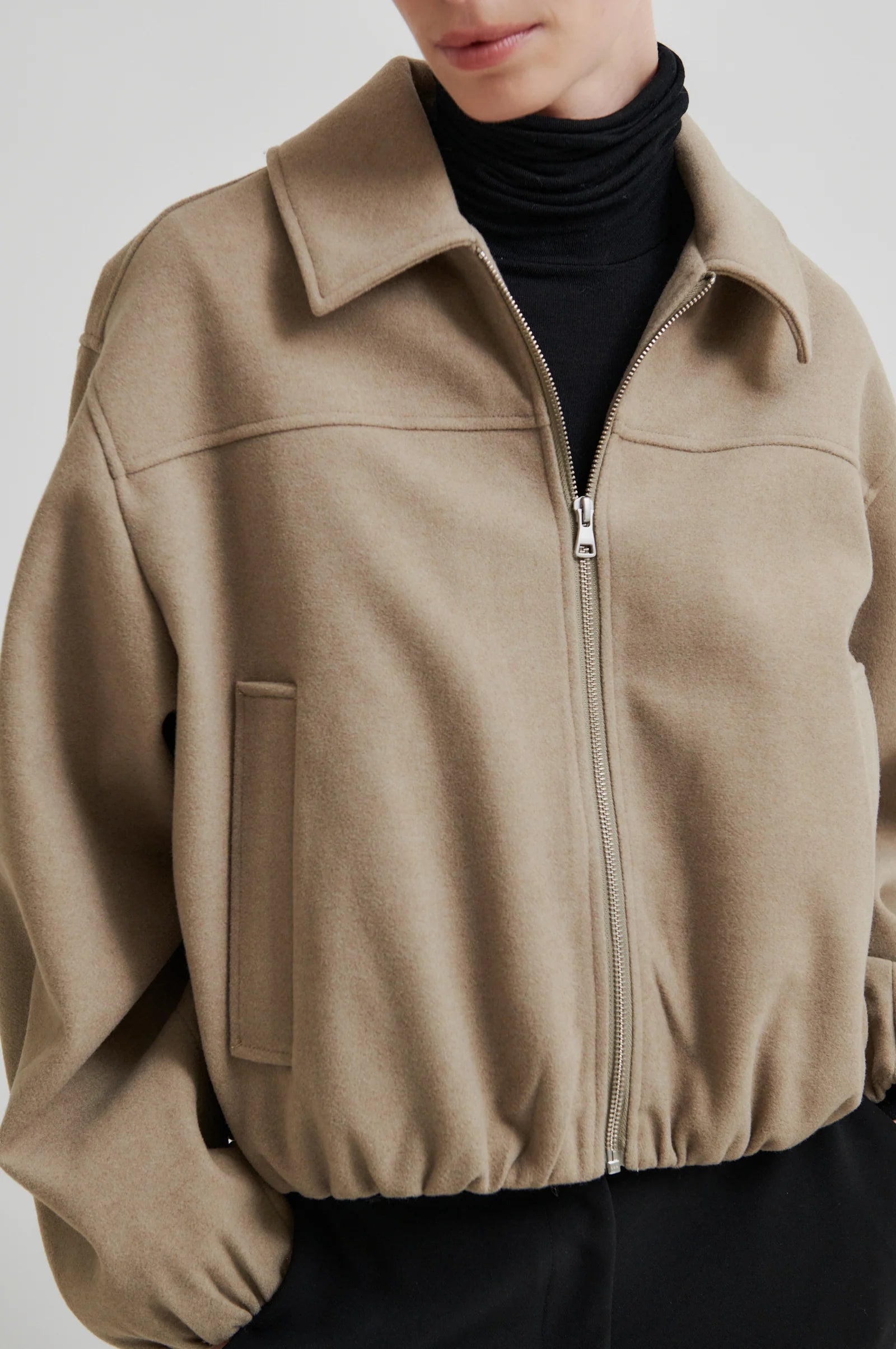 Beige jacket worn by a person on a plain background