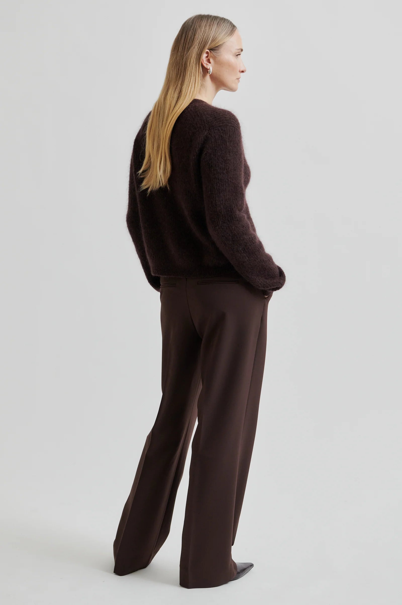 Woman wearing a brown outfit on a plain background