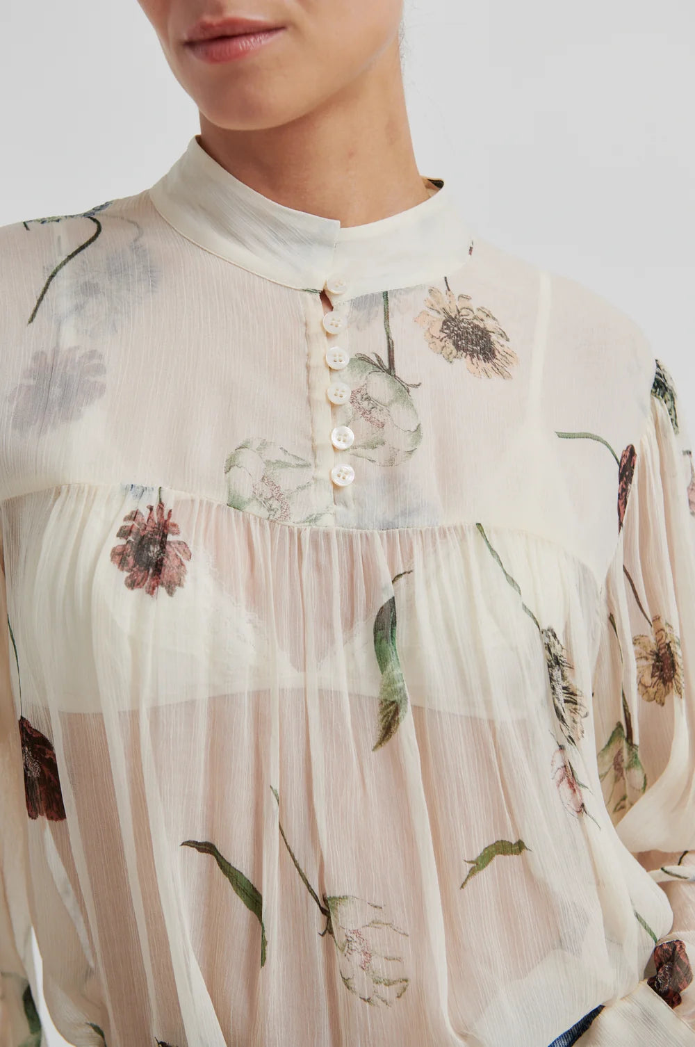 Close-up of a floral-patterned blouse with a neutral background