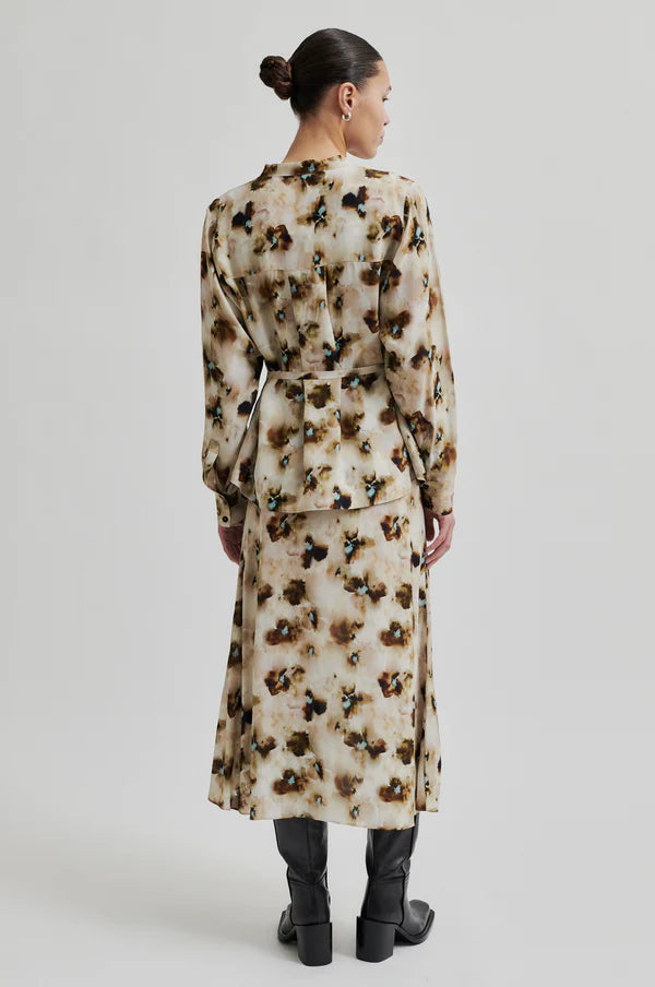 Long sleeve floral print blouse with all over pattern. Tie belt at waist. 