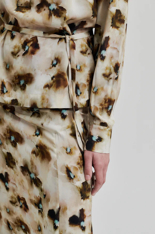 Long sleeve floral print blouse with all over pattern. Tie belt at waist. 
