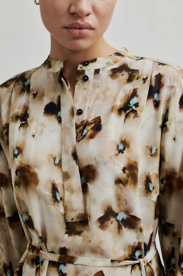 Long sleeve floral print blouse with all over pattern. Tie belt at waist. 
