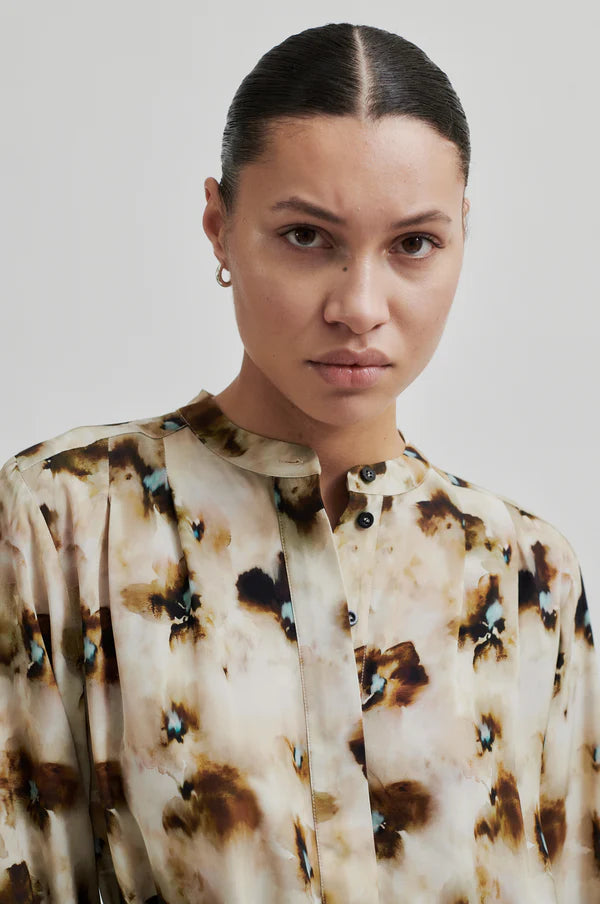 Long sleeve floral print blouse with all over pattern. Tie belt at waist. 