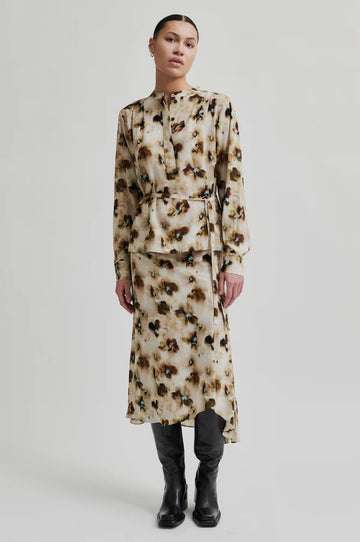 Long sleeve floral print blouse with all over pattern. Tie belt at waist. 