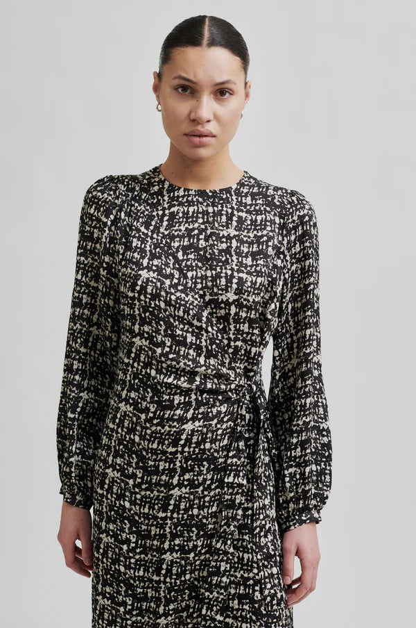 Monochrome long sleeve dress with crossover front that ties to one side.