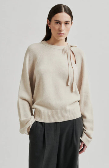 Long sleeve Pumice Colour sweater with slight oversize fit and bow detail at top left shoulder. 