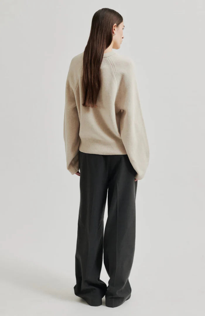 Long sleeve Pumice Colour sweater with slight oversize fit and bow detail at top left shoulder. 